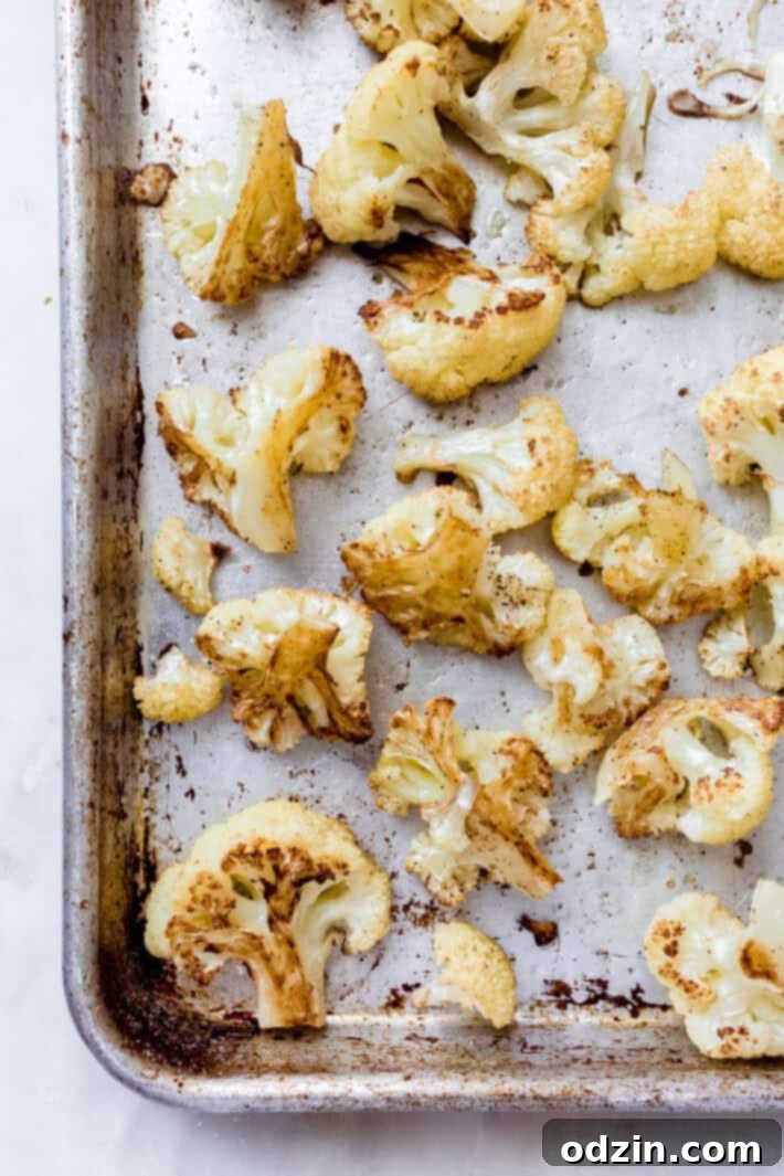 Velvet Truffle Cauliflower Dream 5 Perfectly roasted cauliflower florets spread out on a baking sheet, golden brown and slightly caramelized, fresh from the oven.