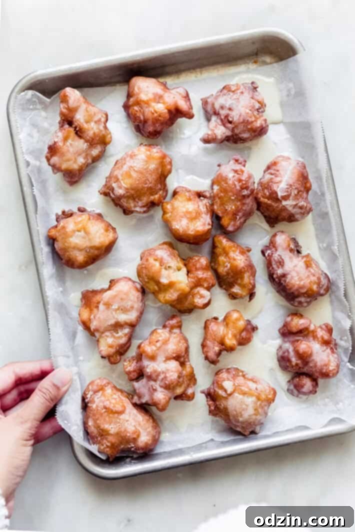 Effortless Maple Honeycrisp Apple Fritters 4 tray with prepared fritters on white marble, hand hold tray