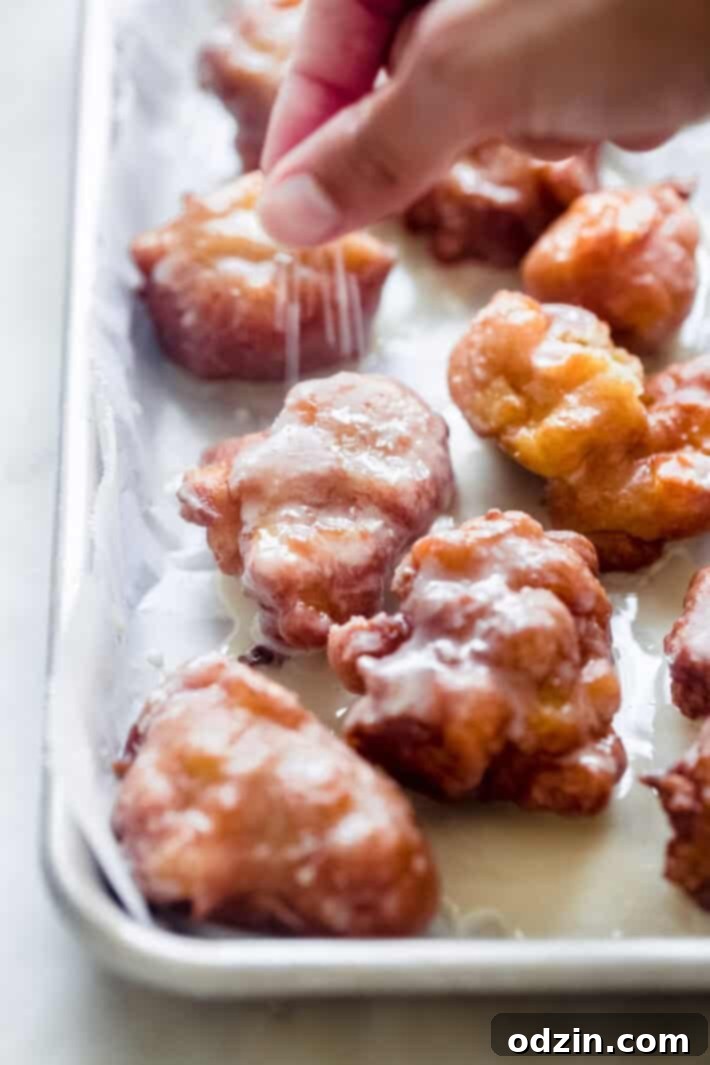 Effortless Maple Honeycrisp Apple Fritters 7 hand sprinkling sparkling sugar on prepared apple fritters