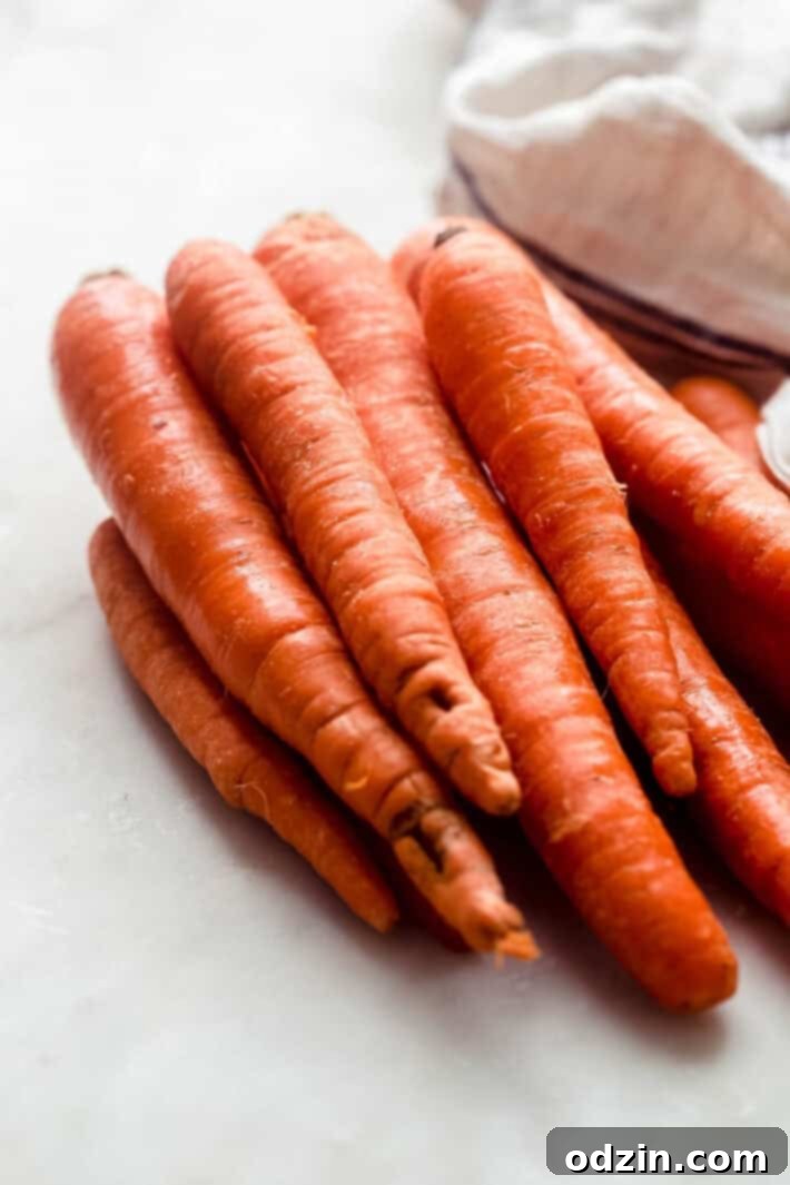 fresh carrots on white marble with kitchen towel