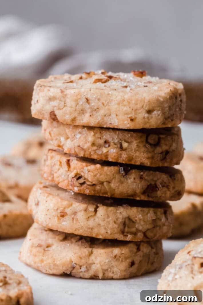 stack of pecan sandies on white parchment
