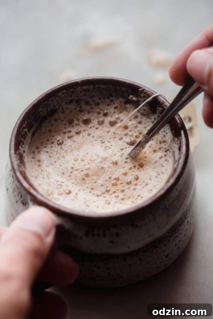 Effortless London Fog Latte 4 hand on mug and spoon stirring latte