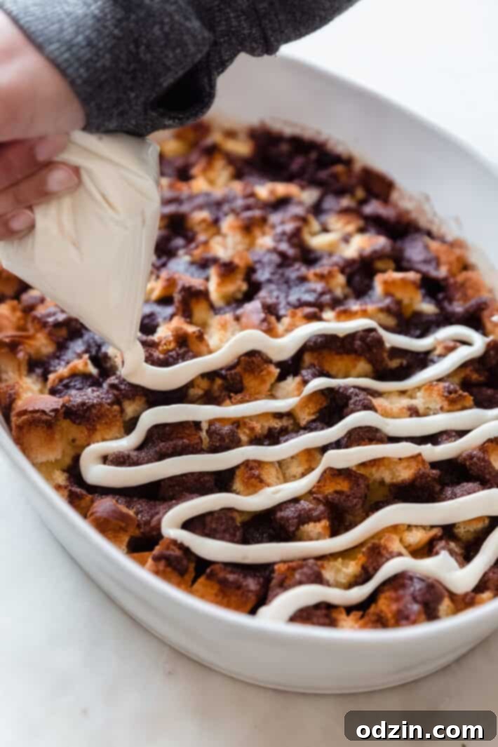 baked casserole with hand squeezing cream cheese icing on top