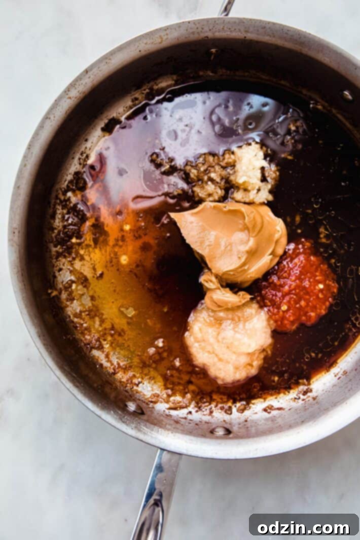 pan with peanut sauce ingredients in saute pan on white marble