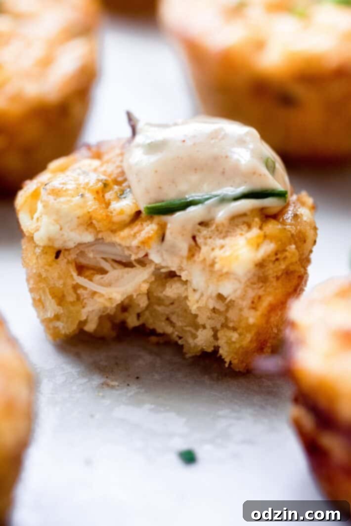 bitten crab cake with sauce and chives on top