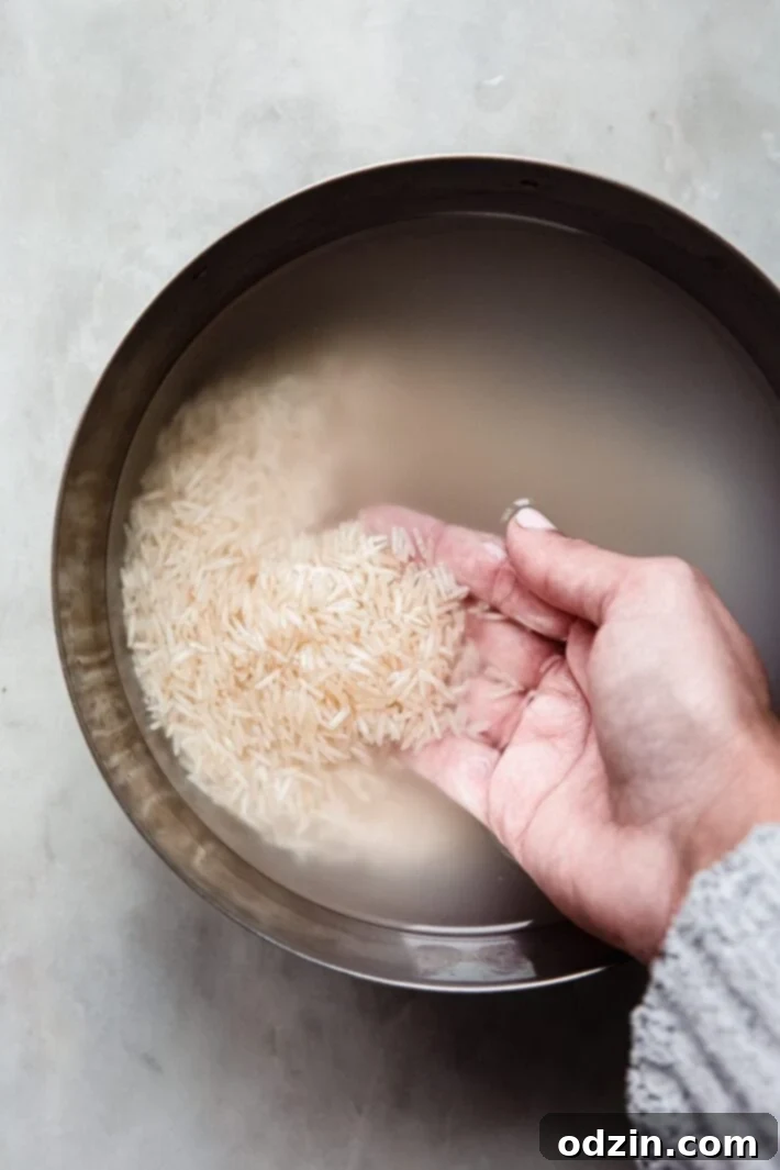 The Secret to Fluffy Indian Restaurant Basmati Rice 5 hand in bowl with soaked basmati rice