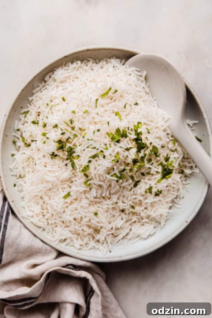 The Secret to Fluffy Indian Restaurant Basmati Rice 7 cooked rice in speckled bowl on white marble with tea towel