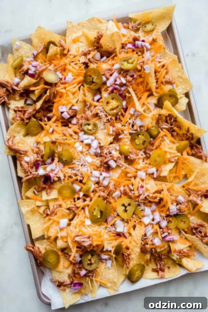 tortilla chips on sheet pan layered with toppings