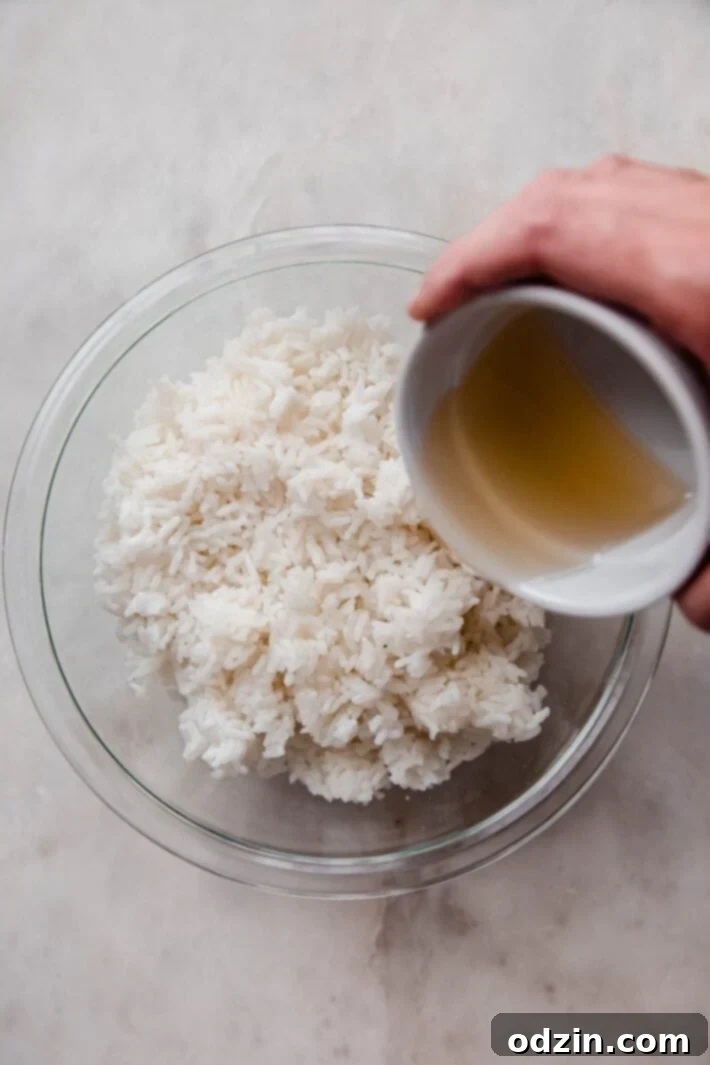 Your Go-To Weeknight Salmon Sushi Bowls 4 jasmine rice being seasoned with rice vinegar, sugar, and salt mixture