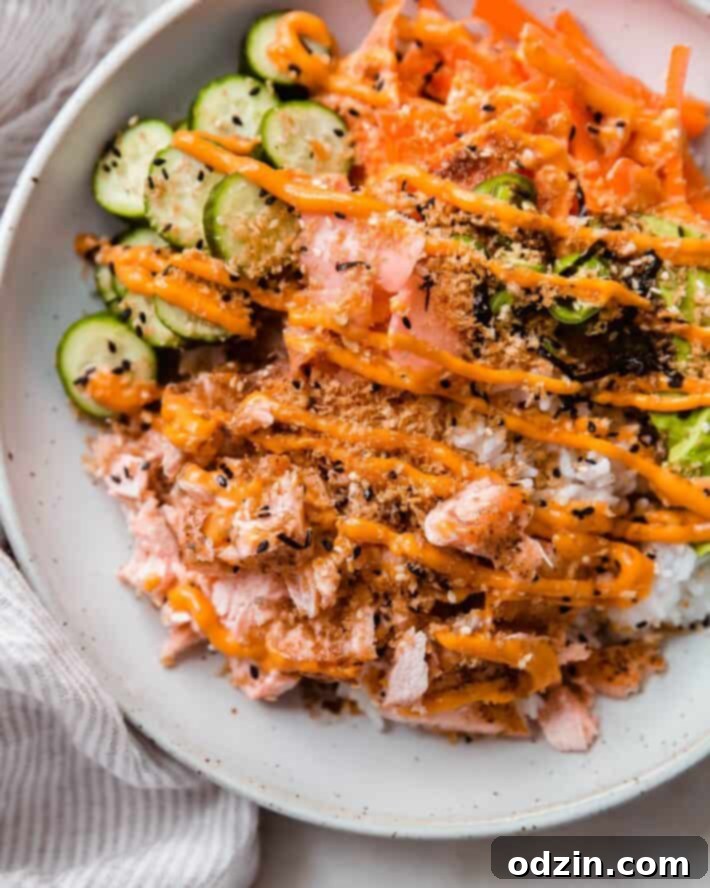 Your Go-To Weeknight Salmon Sushi Bowls 7 close up of toppings in bowl drizzled with sriracha mayo