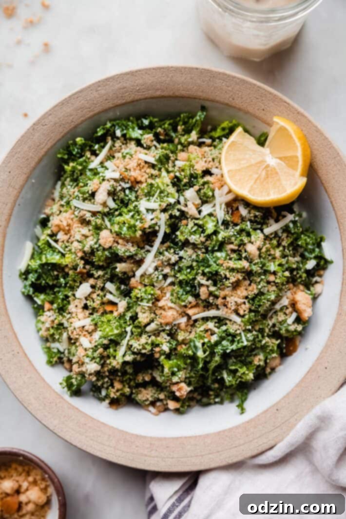 kale salad in bowl with two lemon wedges
