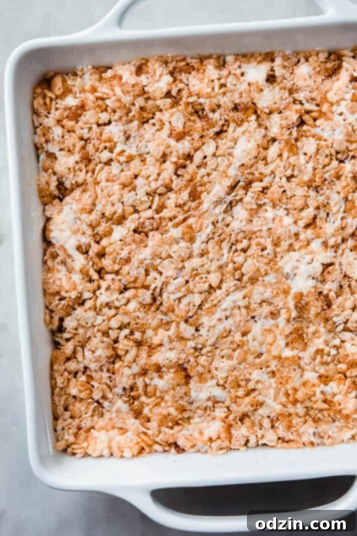 Golden Brown Butter Toasted Marshmallow Krispie Treats 7 Neatly pressed Rice Krispies Treats in a pan, ready to be portioned into squares.