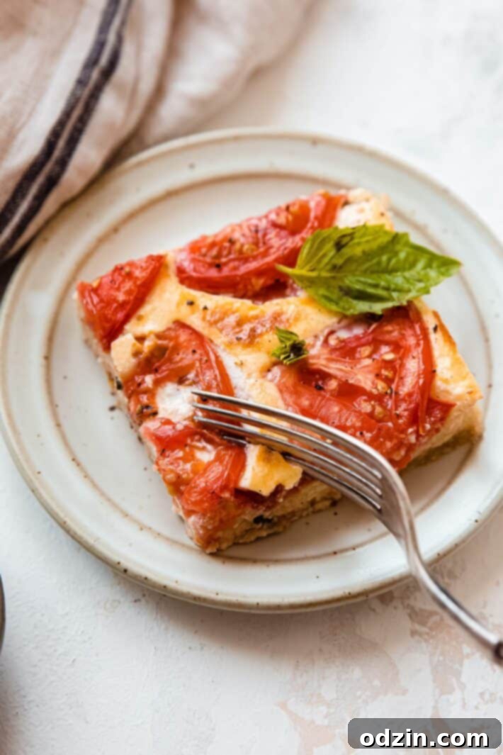Fork breaking a piece of quiche on a speckled plate, showing the creamy texture and inviting crust.