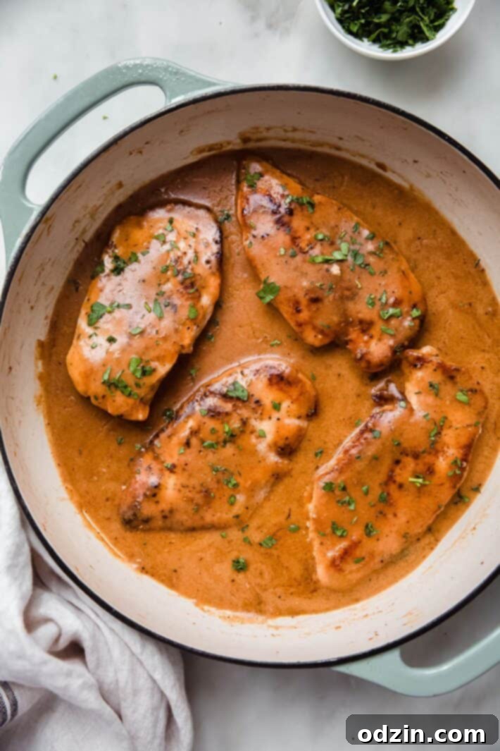 Homestyle Chicken with Gravy and Mashed Potatoes served on a white plate with fresh herbs
