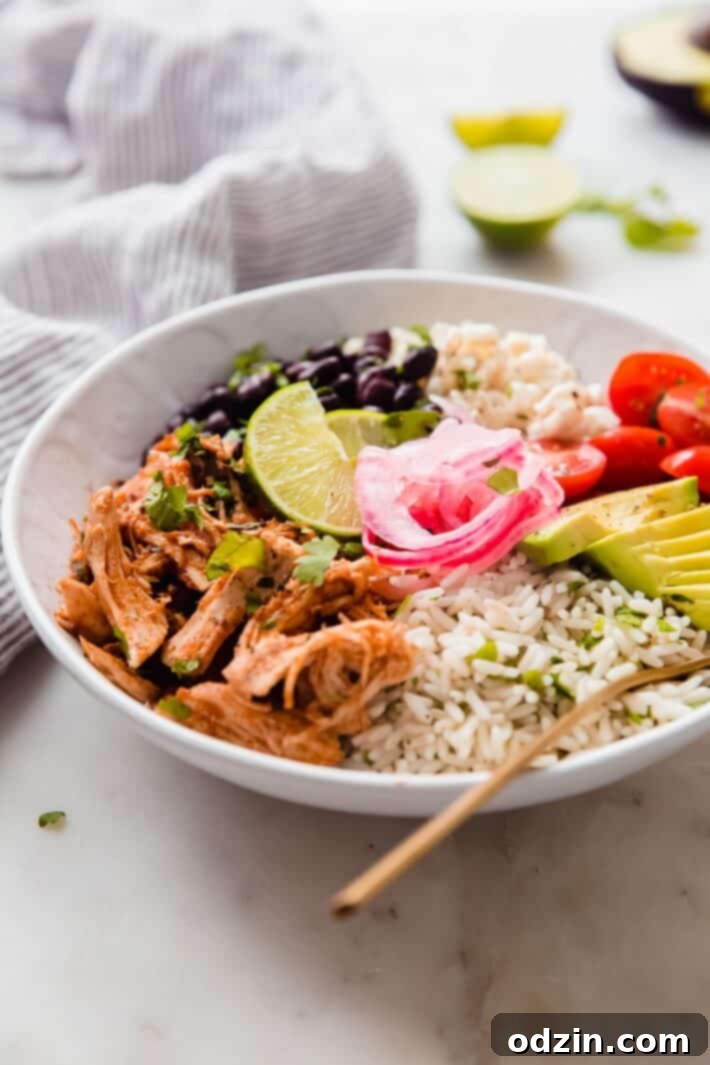Smoky Instant Pot Chicken Tinga Bowls 3 fork in prepared bowl with toppings on white marble