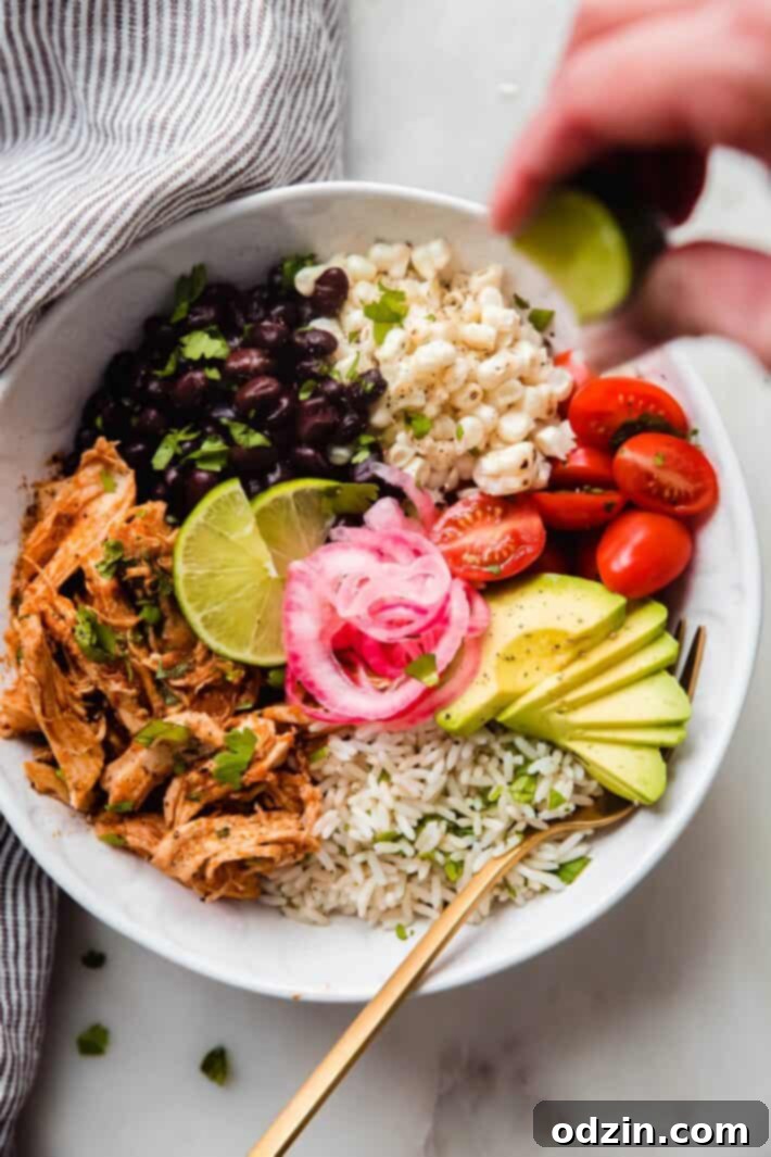 Smoky Instant Pot Chicken Tinga Bowls 7 hand squeezing lime over a chicken Tinga bowl on white marble
