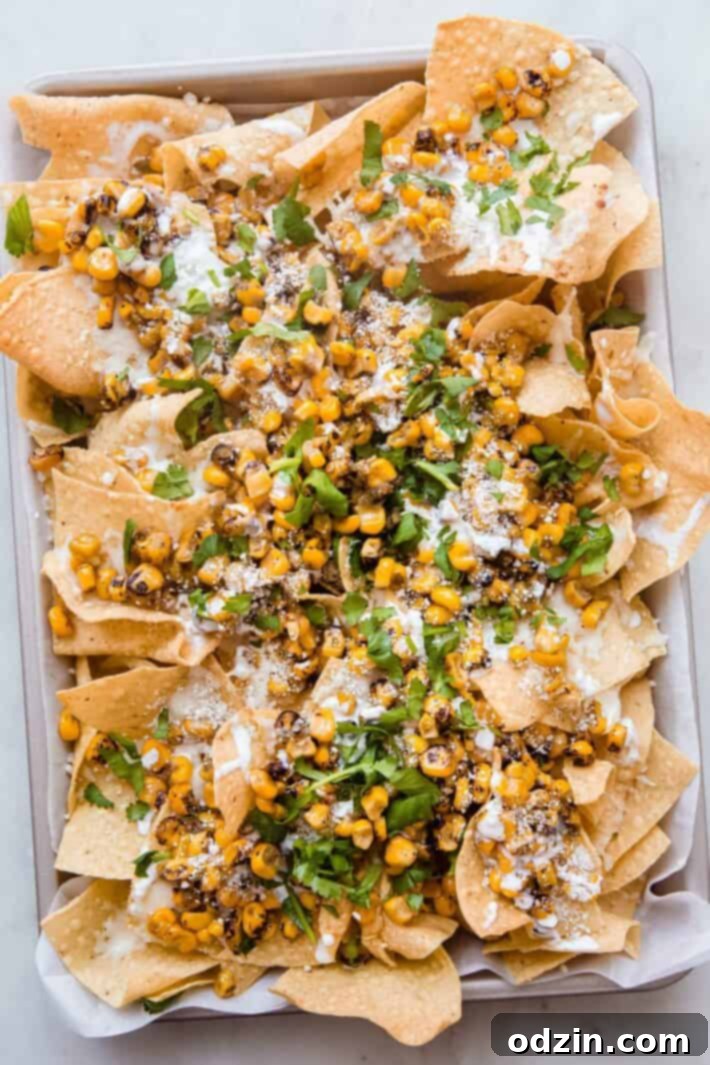 prepared elotes nachos on sheet pan with parchment paper