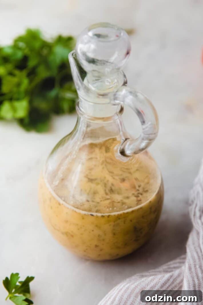 homemade Italian dressing in glass bottle on white marble