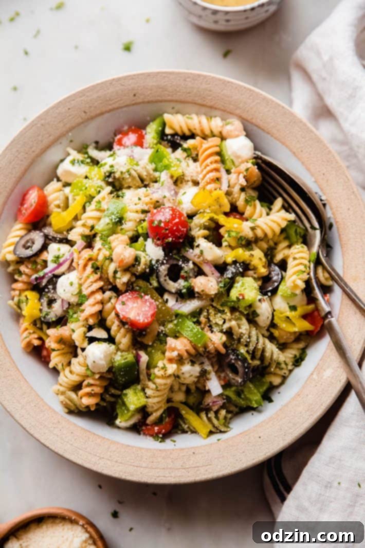 Crowd-Pleasing Zesty Italian Pasta Salad 7 pasta salad in rimmed plate on white marble