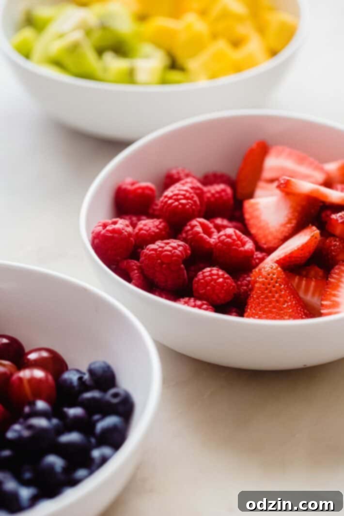assorted fresh fruits in white bowls for fruit pizza topping