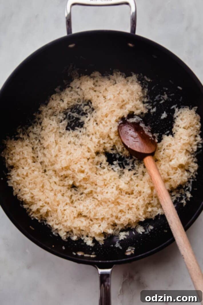 sautéed rice in pan with wooden spoon