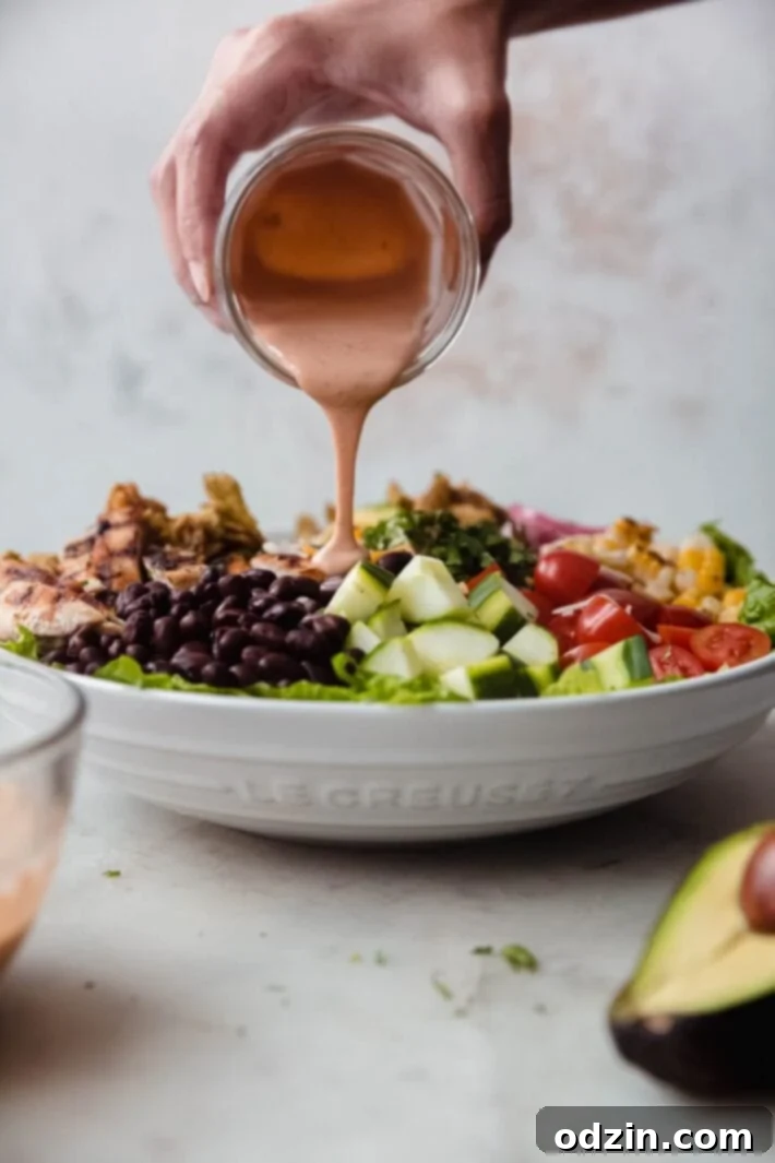 bbq ranch salad dressing being drizzled generously on a large salad
