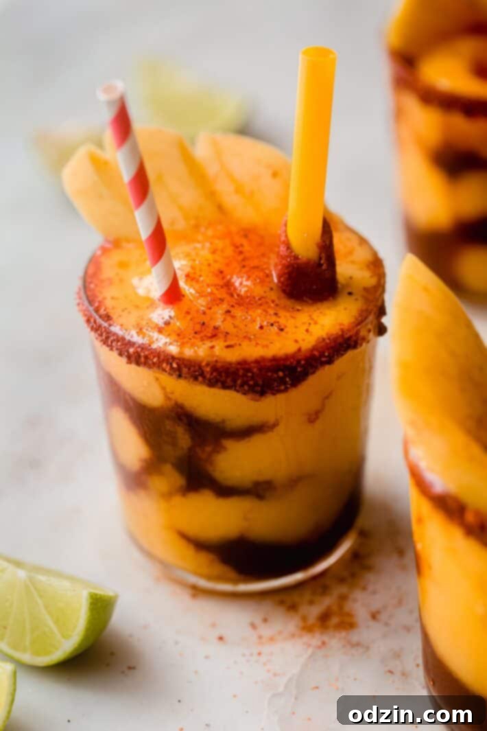 Refreshing Mangonada layered with Chamoy and Tajin in a clear glass