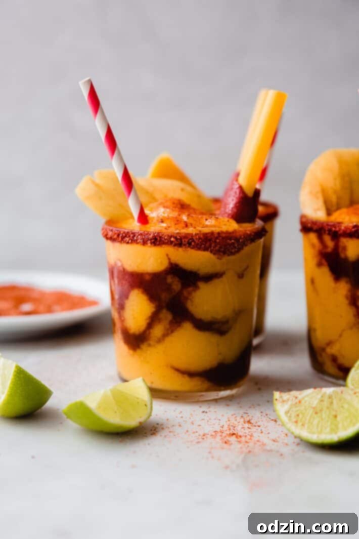 Chamango drink on white marble with tajin rim and lime wedges