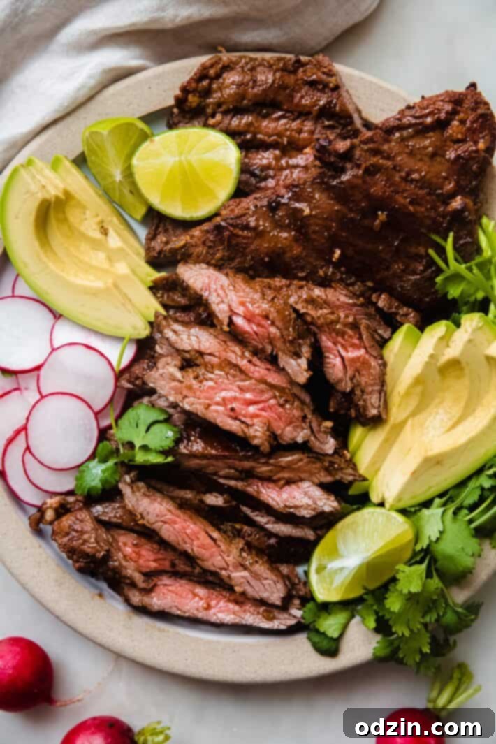 A vibrant plate featuring thinly sliced carne asada steak, garnished with fresh cilantro, radish slices, and lime wedges, ready to be enjoyed.