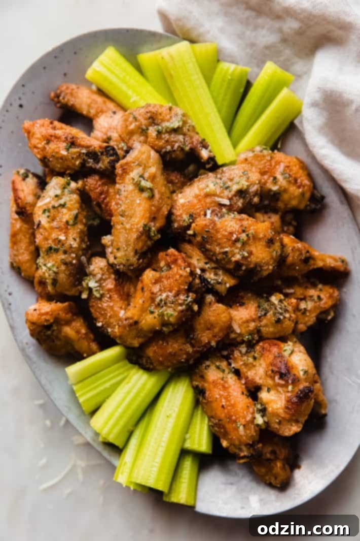 Shatteringly Crispy Garlic Parmesan Wings 2 garlic parmesan wings with celery on metal plate