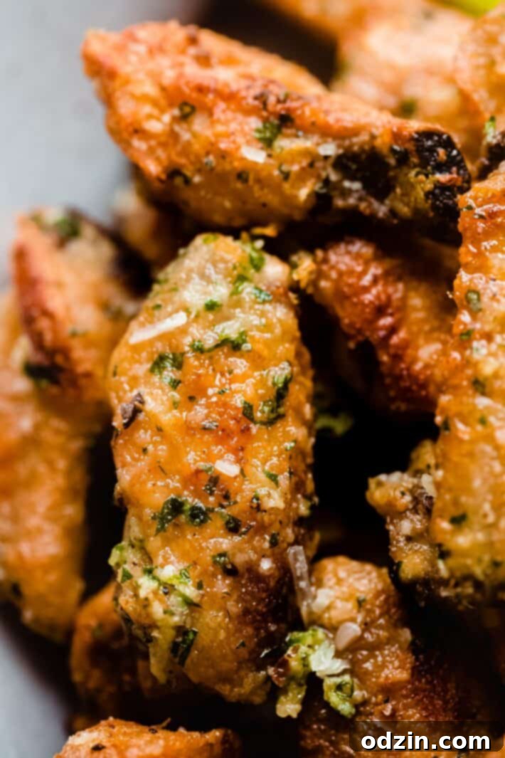 Shatteringly Crispy Garlic Parmesan Wings 3 golden garlic parmesan wing on plate