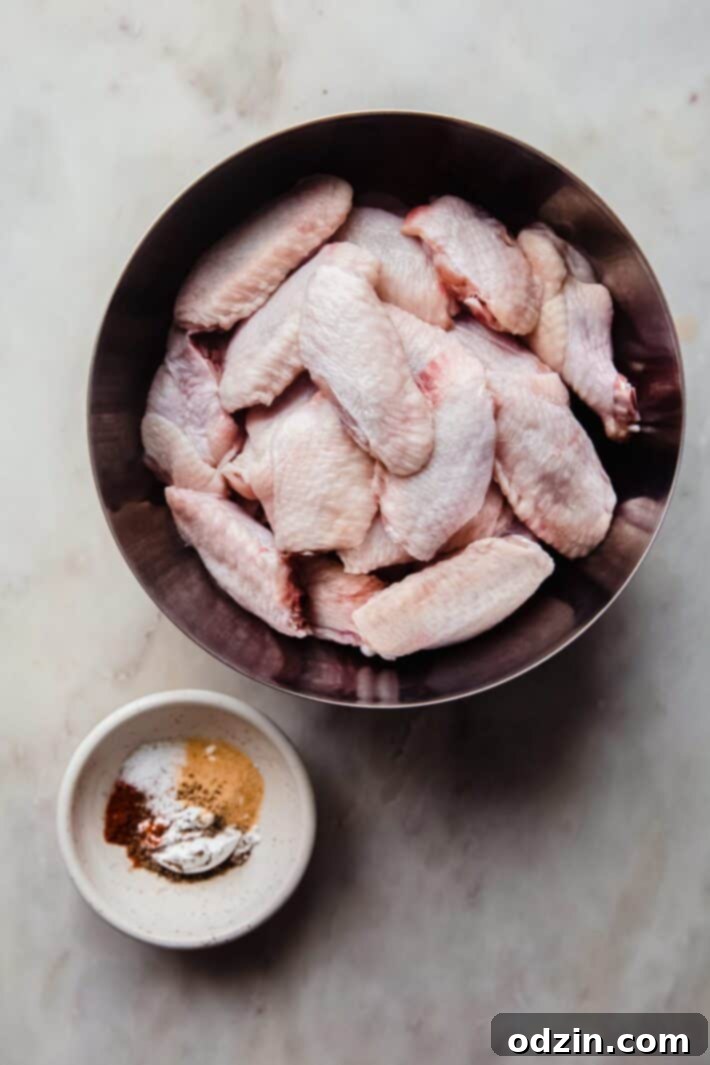 Shatteringly Crispy Garlic Parmesan Wings 4 wings in bowl with seasoning in another bowl