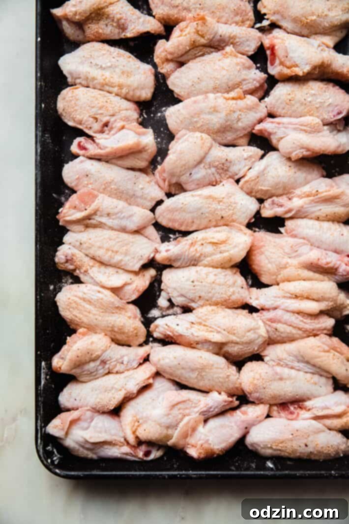 Shatteringly Crispy Garlic Parmesan Wings 5 seasoned wings on baking sheet