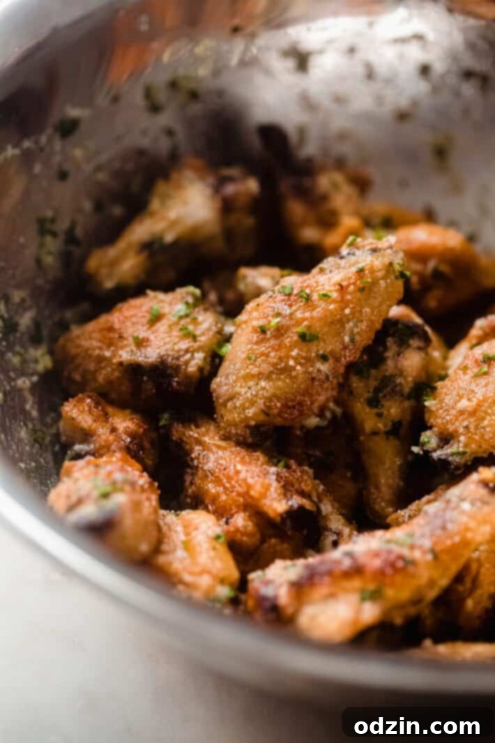 Shatteringly Crispy Garlic Parmesan Wings 7 wings tossed in garlic parmesan butter in metal bowl