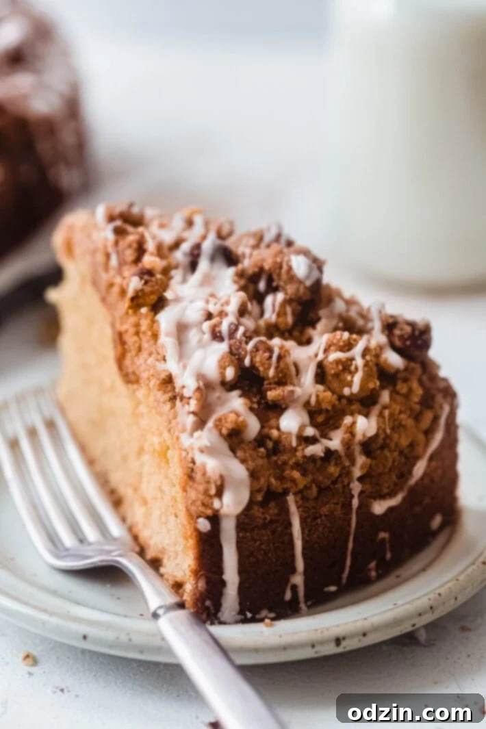 Decadent Brown Butter Cinnamon Pecan Coffee Cake 7 sliced coffee cake with icing on plate with fork