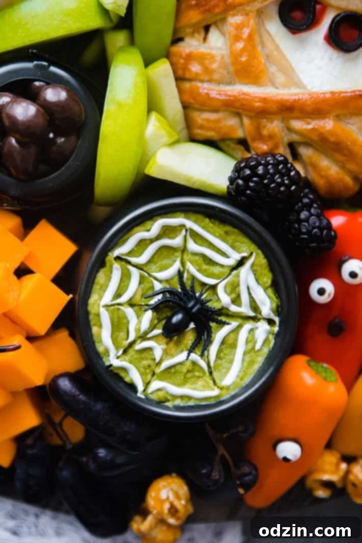 guacamole with a swirl of sour cream and a faux spider
