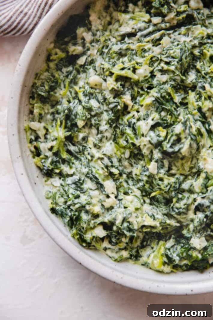 Close-up of rich, creamy homemade spinach in a rustic bowl, garnished for serving