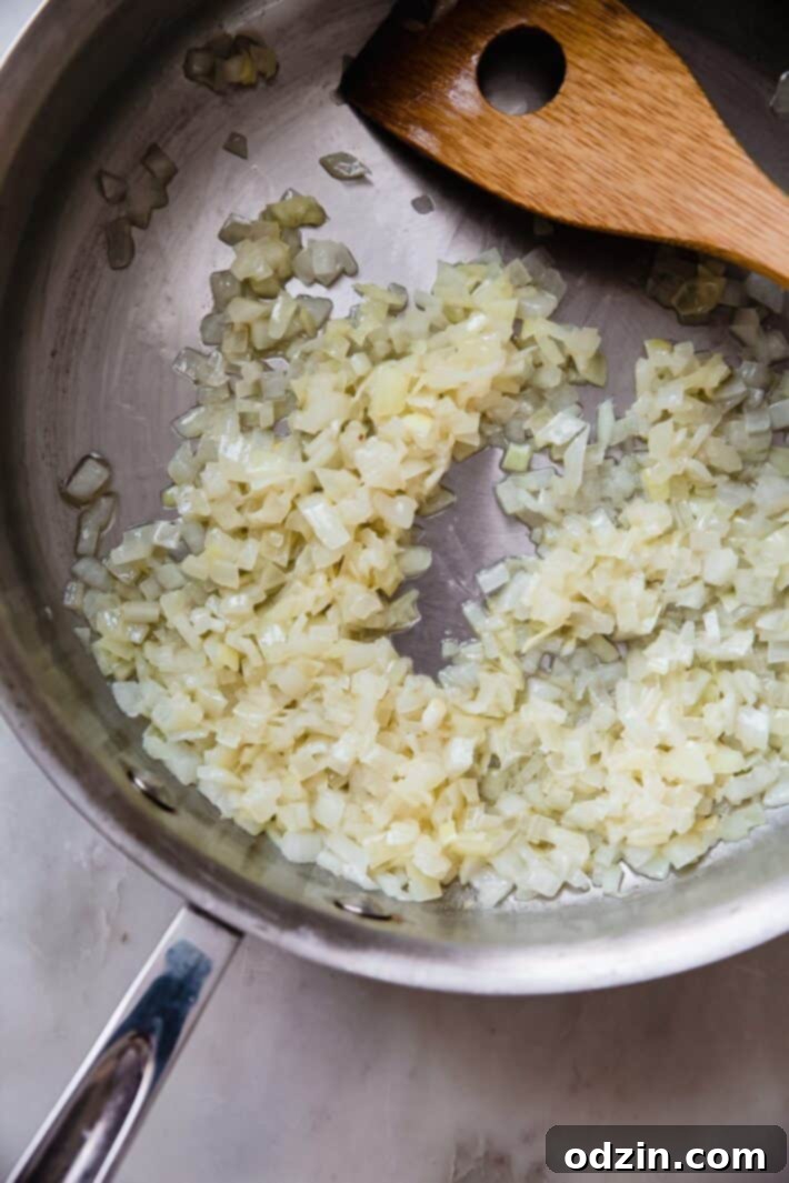 Finely chopped onions sautéing in butter in a large skillet until translucent