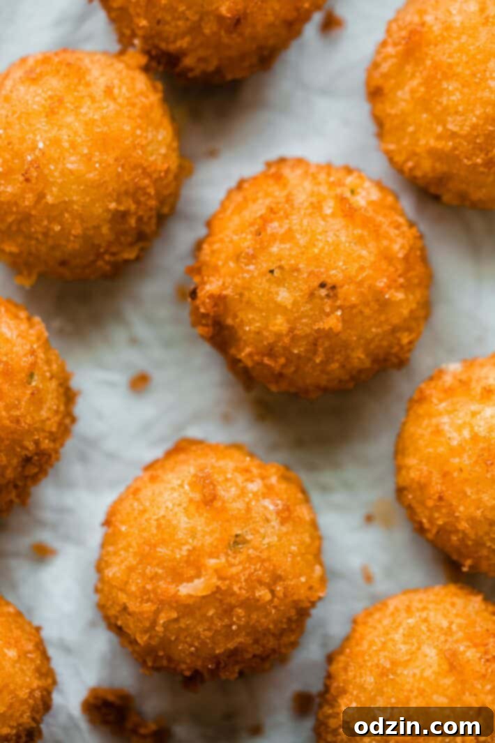 fried potato balls on paper towel lined baking sheet
