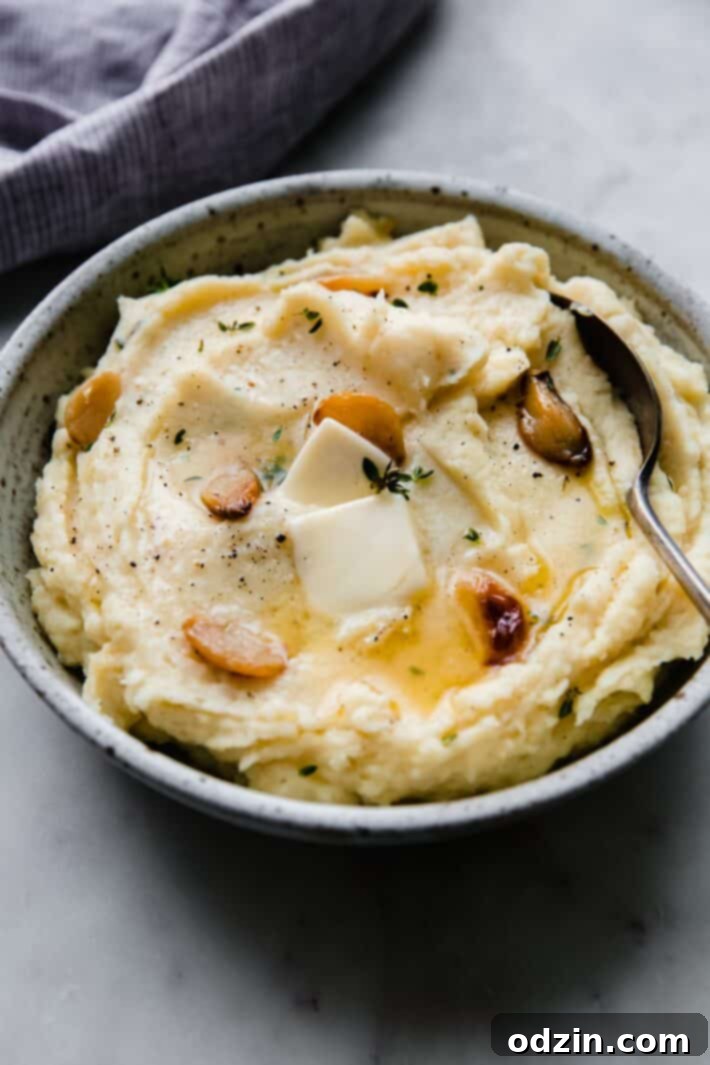 garlic mashed potatoes in speckled bowl with spoon