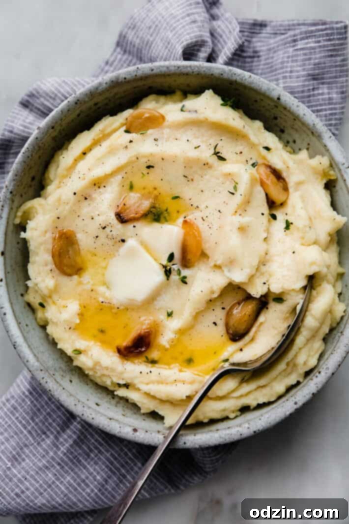 bowl of mashed potatoes with spoon on striped towel