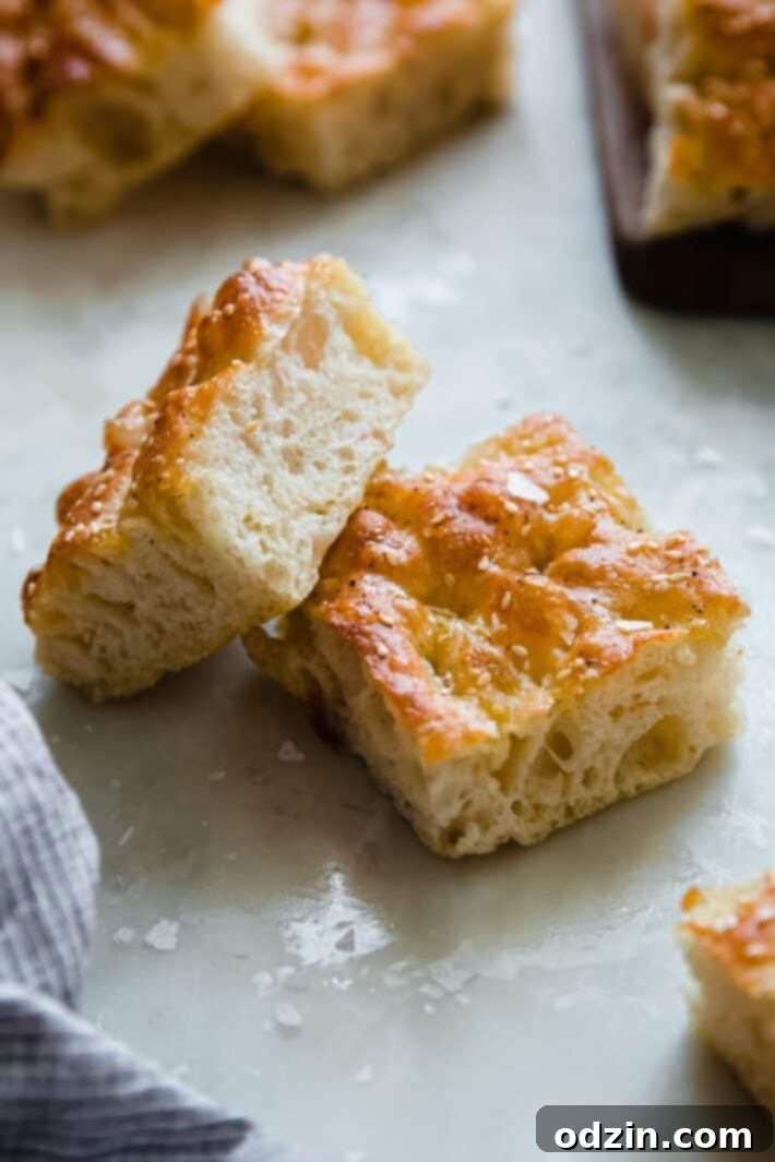 two squares of focaccia bread on white marble