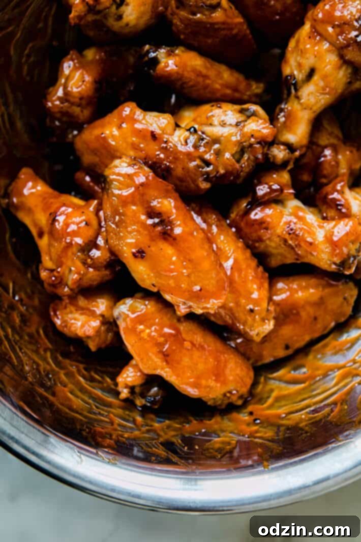 Pile of firecracker wings garnished with fresh green onions.