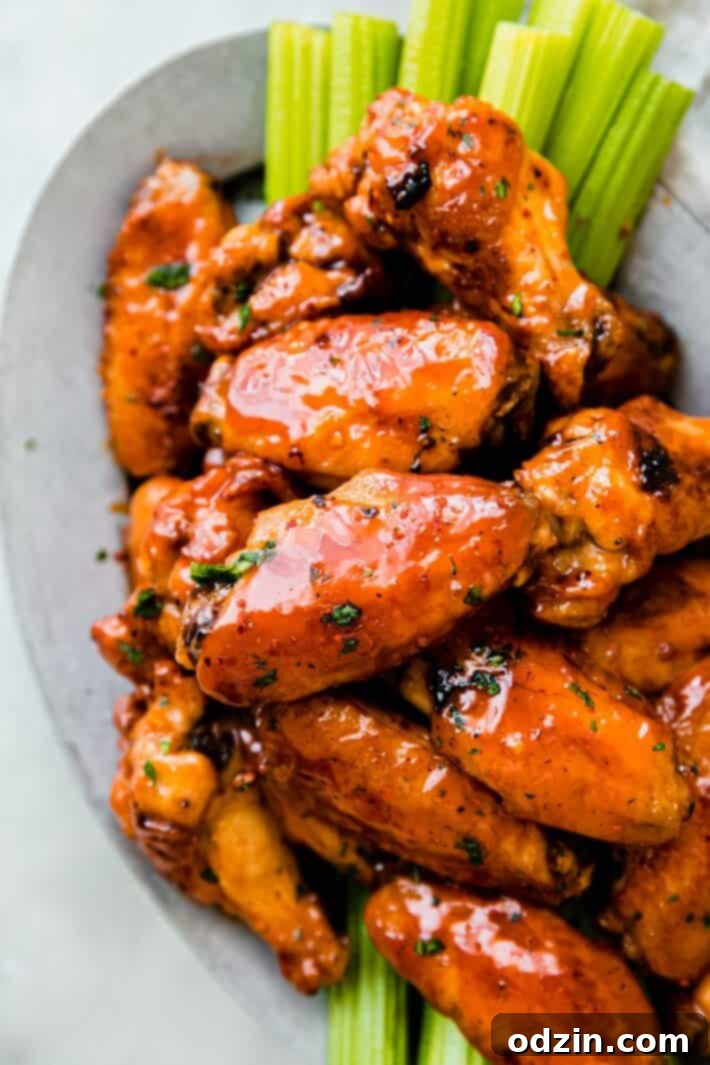 Close-up of a single crispy firecracker chicken wing, perfectly coated in sauce and ready to eat.