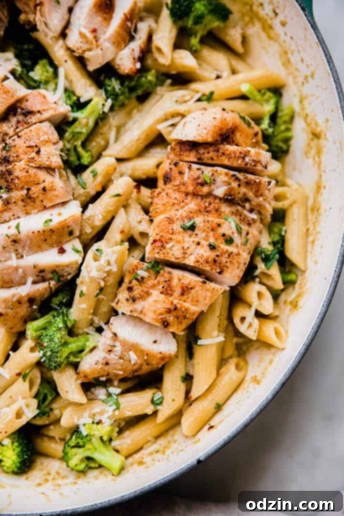 Velvety Pesto Chicken Pasta 3 sliced chicken on a bed of penne pasta with broccoli