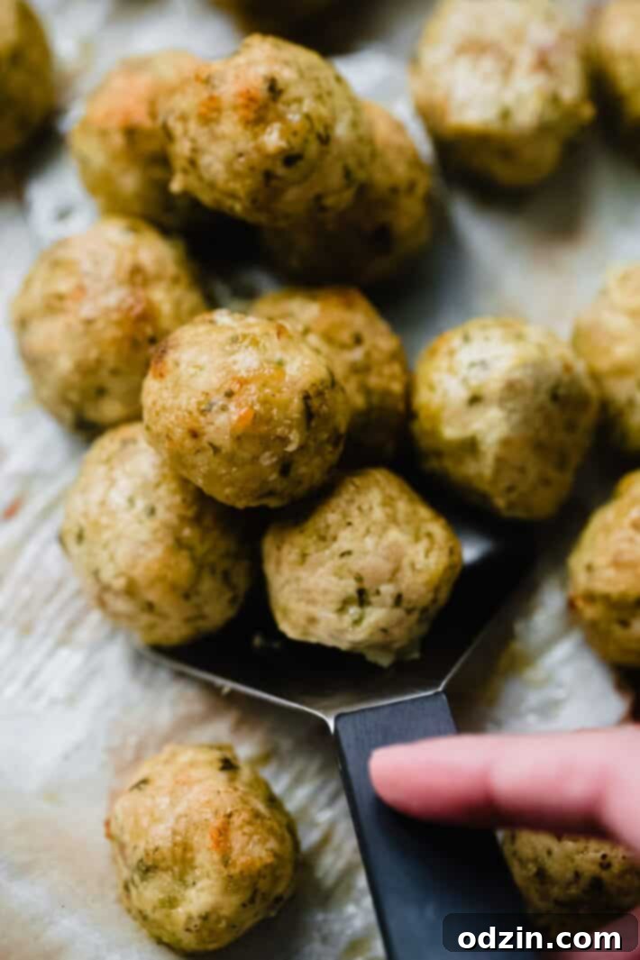 pesto chicken meatballs on tray with spatula