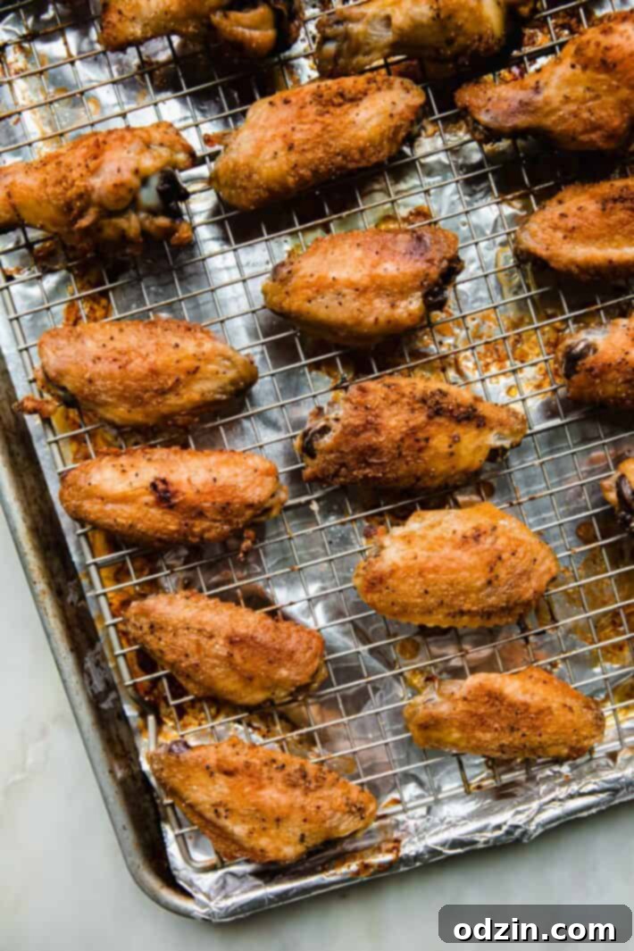 Crispy baked chicken wings on a wire rack set over a baking sheet, fresh out of the oven.