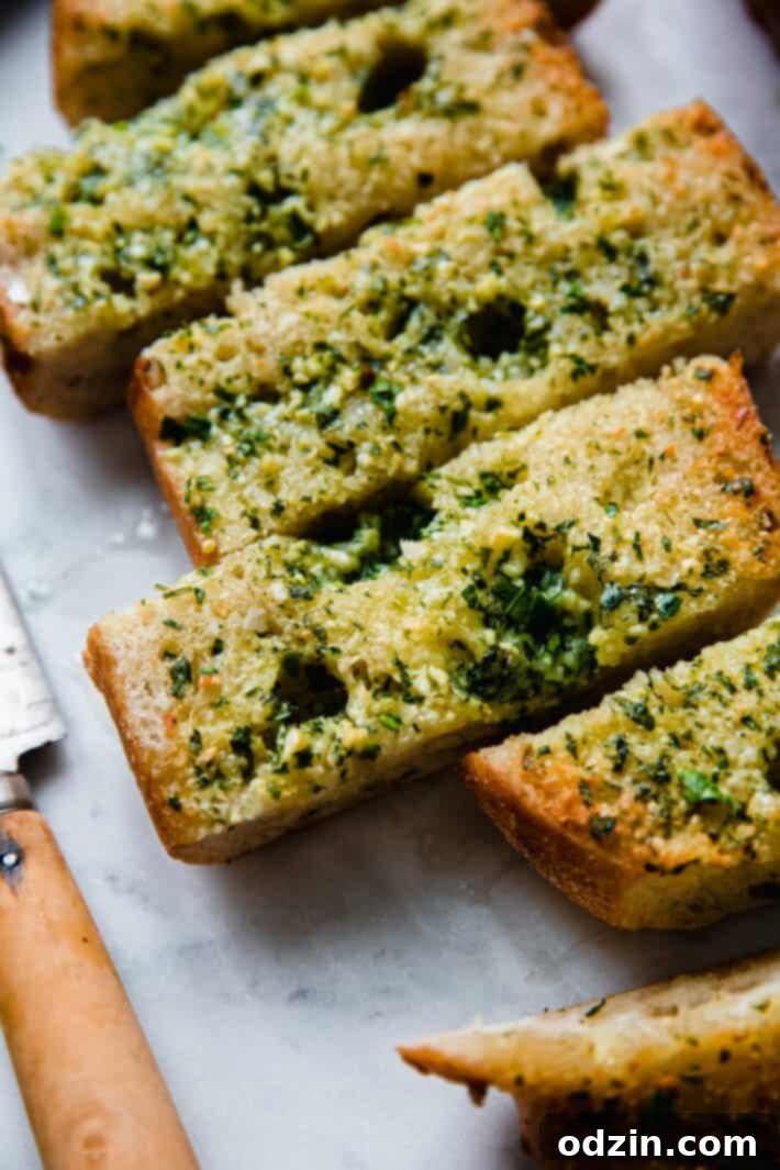 The Ultimate Garlic Bread 3 Golden-brown garlic bread topped with fresh parsley, served with a knife