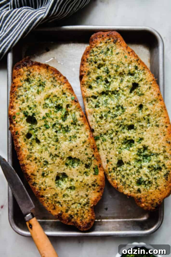 The Ultimate Garlic Bread 6 Freshly baked garlic bread, golden and crispy, on a quarter sheet pan