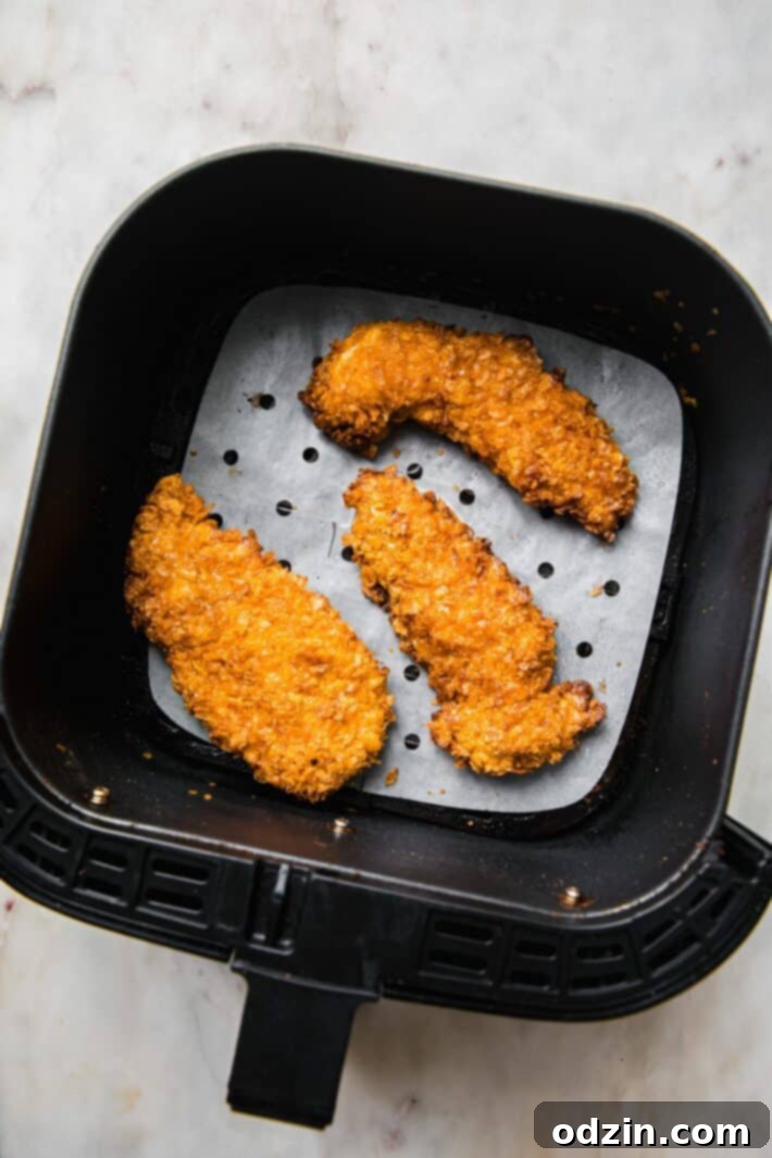 Golden Crispy Air Fryer Chicken Tenders 5 chicken tenders in the air fryer basket
